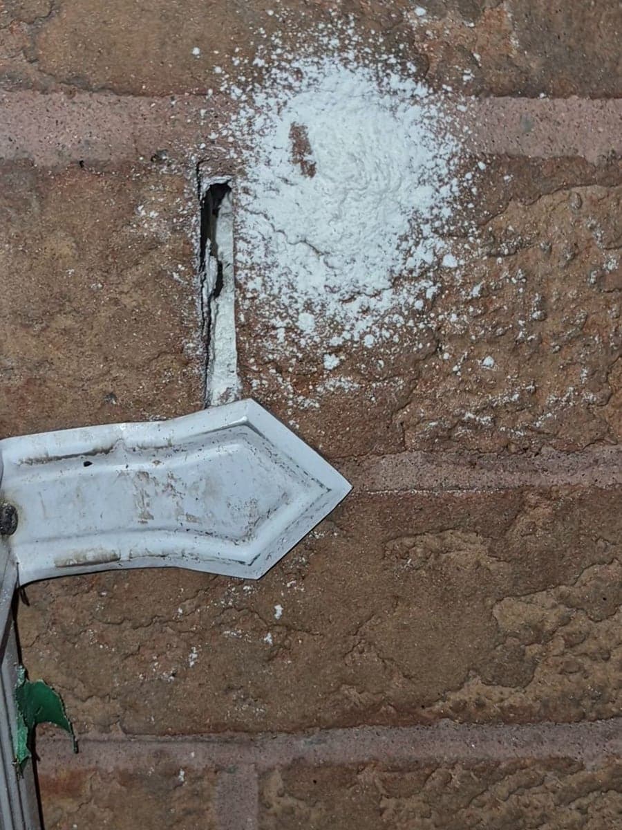 The same narrow opening in the brick wall with treatment applied around it.
